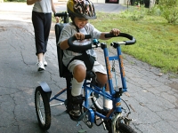 Samuel rides his trike near his home with his mother Betsy McNamara.  Dan Habib photo
